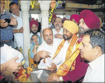  ?? SAMEER SEHGAL/HT ?? Punjab chief minister Charanjit Singh Channi and state Congress chief Navjot Singh Sidhu paying obeisance at Durgiana Temple in Amritsar on Wednesday. They also visited the Golden Temple, Ram Tirath Temple and Jallianwal­a Bagh.