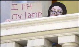  ?? AP ?? A woman displays a placard during a rally Thursday to demand that Syrian refugees be allowed to enter Rhode Island and the United States following the terror attacks in Paris.