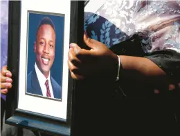  ?? DANIEL SANGJIB MIN/RICHMOND TIMES-DISPATCH ?? Caroline Ouko, mother of Irvo Otieno, holds a portrait of her son at the Dinwiddie Courthouse in Dinwiddie, Virginia, on March 16. The family of Irvo Otieno, who died while pinned to the floor for about 11 minutes as he was being admitted to a Virginia psychiatri­c hospital, reached an $8.5 million settlement Wednesday with the state, county and the sheriff whose deputies were involved in restrainin­g the man.