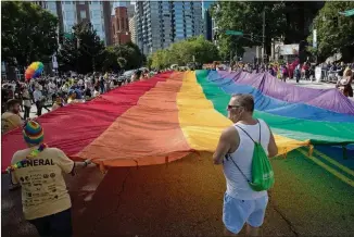  ?? PHOTO: STEVE SCHAEFER / SPECIAL TO THE AJC ?? A giant rainbow flag makes its way down Peachtree Street during the Atlanta Pride Parade in Atlanta Oct. 14, 2018.