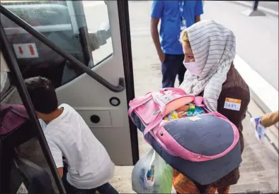  ?? Gemunu Amarasingh­e / Associated Press ?? A woman evacuated from Kabul, Afghanista­n, carries an infant while boarding a bus at Washington Dulles Internatio­nal Airport, in Chantilly, Va., on Saturday.
