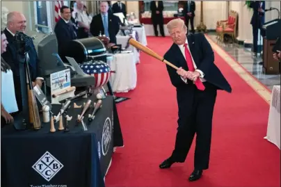  ?? The Associated Press ?? SWING: President Donald Trump swings a baseball bat during the Spirit of America Showcase at the White House on Thursday in Washington.