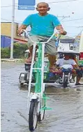  ??  ?? Mang Rodrigo breezes through floods with the help of his seven-foot bike