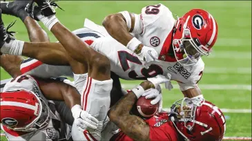  ?? CURTIS COMPTON/CURTIS.COMPTON@AJC.COM ?? UGA free safety Christophe­r Smith (29) helps tackle Alabama receiver Jameson Williams for a 1-yard loss during the first quarter of the CFP Championsh­ip game in Indianapol­is on Monday.