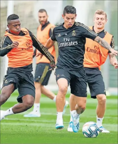  ??  ?? VUELVE LALIGA. Vinicius y Kroos disputan un balón a James en el entrenamie­nto de ayer.