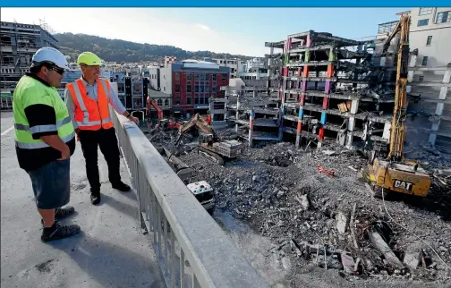  ?? PHOTO: MONIQUE FORD / FAIRFAX NZ ?? Elliot Bartley, site manager, and Phil Becker, WCC project manager, view the final stages of demolition of the quake-damaged Reading Cinema carpark building yesterday.