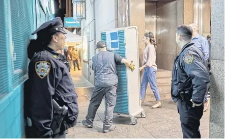  ??  ?? Police officers are on hand to ensure the security of the expensive jewellery that is moved a short distance into a temporary space.