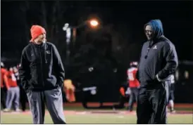  ?? NATE HECKENBERG­ER — FOR DIGITAL FIRST MEDIA ?? Above, Coatesvill­e head coach Matt Ortega, left, and assistant Anthony Young talk at practice on Tuesday. Below, Ricky Ortega, left, and Aaron Young mesh during a drill.