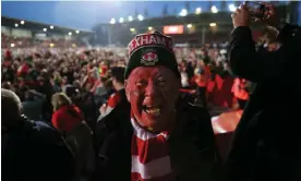  ?? Photograph: Simon Stacpoole/Offside/Getty Images ?? Wrexham fans celebrate on the pitch after the victory over Boreham Wood at the Racecourse Ground on Saturday.