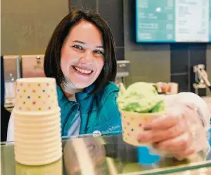  ?? Tyler Sizemore/Hearst Connecticu­t Media ?? Owner Anna Buzik scoops ice cream at Cups n’ Cones in Old Greenwich on March 21, 2022. Located at the former site of Rosie’s Frozen Yogurt, the shop features a variety of frozen yogurt, ice cream, waffles, milkshakes and more in a colorful, renovated space.