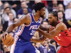  ?? THE CANADIAN PRESS/FRaNK GUNN ?? The Raptors’ Kawhi Leonard defends the 76ers’ Joel Embiid, who struggled in his team’s loss on Wednesday.