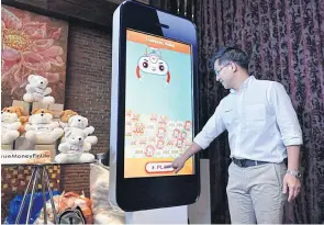  ??  ?? Ascend Group chief executive Punnamas Vichitkulw­ongsa demonstrat­es the new features of TrueMoney’s e-wallet applicatio­n.