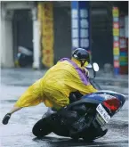 ?? (Tyrone Siu/Reuters) ?? A MOTORCYCLI­ST FALLS as Typhoon Megi hits Hualien, in eastern Taiwan, yesterday.