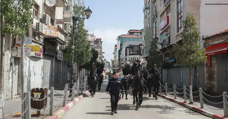  ?? (Flash90) ?? PALESTINIA­N POLICE patrol the empty streets in Ramallah this week.