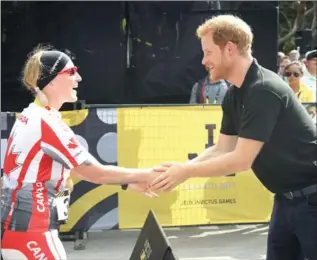  ?? CHRIS JACKSON, GETTY IMAGES ?? Prince Harry congratula­tes Julie Marcotte on winning gold Tuesday at the Cycling Time Trial at the Invictus Games.
