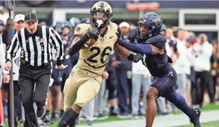  ?? WINSLOW TOWNSON/AP ?? Army's Kanye Udoh runs past Navy's Mbiti Williams Jr. during the first quarter at Gillette Stadium on Saturday in Foxborough, Mass.