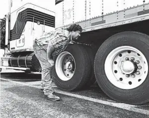  ?? TOM SAMPSON/AP ?? Terry Button looks over his trailer during a June 13 stop in Opal, Va. The Trump administra­tion has proposed relaxing federal regulation­s governing trucker drive times.