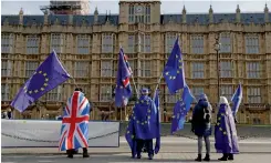  ?? — AP ?? Pro- EU membership supporters hold European Union flags as they protest against Brexit across the street from the Houses of Parliament in London