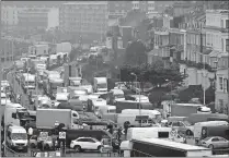  ?? [FRANK AUGSTEIN/ THE ASSOCIATED PRESS] ?? Vehicles are parked Wednesday at the entrance to the Port of Dover, that is blocked by police, as they wait to be allowed to leave, in Dover, England. Freight from Britain and passengers with a negative coronaviru­s test have begun arriving on French shores, after France relaxed a two-day blockade over a new virus variant. The blockade had isolated Britain, stranded thousands of drivers and raised fears of shortages.