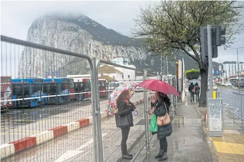  ?? PHOTOS BY REUTERS ?? RIGHT Women talk through a fence in the British overseas territory of Gibraltar.