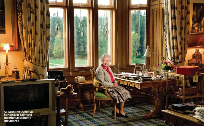  ?? ?? At ease: The Queen at her desk in Balmoral – the Highlands home she adored