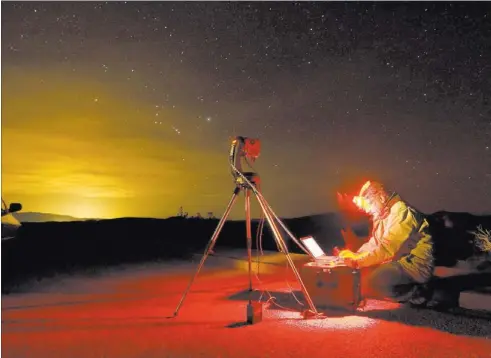  ?? JOHN LOCHER/ LAS VEGAS REVIEW-JOURNAL FILE ?? Dan Duriscoe works at a special computer-controlled camera used to photograph the night sky at Dante’s View in Death Valley National Park, Calif. The light in the sky on the left horizon is light from Las Vegas 85 miles away. Nevada has some of the...