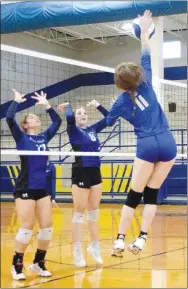  ?? Westside Eagle Observer/MIKE ECKELS ?? Lady Bulldog Brooklyn Todd (11) spikes the ball back over the net and over the hands of a pair of Lady Griffins during the Decatur-Ozark Catholic Academy volleyball contest in Decatur on Sept. 26.