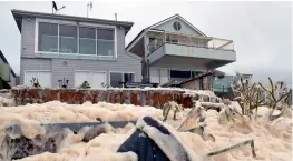  ?? — AP ?? Sea foam brought by waves outside beach front houses after heavy rain and storms at Collaroy in Sydney’s Northern Beaches on Monday.