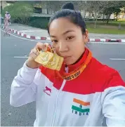  ?? — PTI ?? Weightlift­er Mirabai Chanu poses after winning gold at the EGAT Cup in Chiang Mai, Thailand, on Thursday.