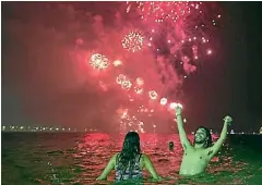  ??  ?? People watch the fireworks exploding over Copacabana Beach in Rio de Janeiro.