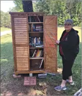  ?? Photo by George Smith ?? ■ Bobbie Smith stands by a large, weatherpro­of small library she helped set up on a Nevada Country road.