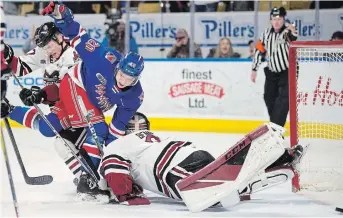  ?? MATHEW MCCARTHY WATERLOO REGION RECORD ?? Isaac Langdon of the Kitchener Rangers scores as he gets tangled with Guelph Storm goaltender Owen Bennett in second-period OHL action at the Aud on Sunday.