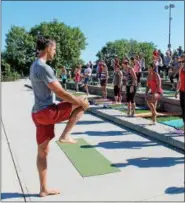  ??  ?? Andrew Kasius, co-owner of Heartspace Yoga at 10 Second St. in downtown Troy, instructin­g yoga on a Sunday morning at Riverfront Park in downtown Troy as part of the Downtown Business Improvemen­t District’s Fitness in the Park series.
