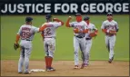  ?? ELIZABETH FLORES — STAR TRIBUNE VIA AP ?? The Red Sox celebrate their win over the Twins. In the background is a sign referring to George Floyd, who died while in police custody last May.