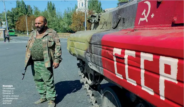  ??  ?? Nostalgia Un miliziano filorusso, a Donetsk, in Ucraina, vicino a un blindato con il simbolo dell’Urss