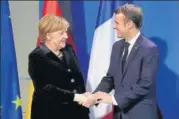  ?? AP ?? German Chancellor Angela Merkel and French President Emmanuel Macron shake hands in Berlin on Sunday.