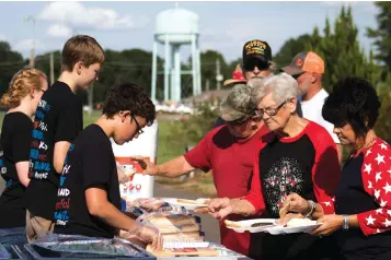  ??  ?? top People buy burgers Tuesday from Boy Scouts of Troop 36 as they enjoy the Independen­ce Day festivitie­s in downtown New Boston, Texas.