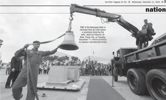  ?? (PHOTO COURTESY US EMBASSY INFORMATIO­N OFFICE) ?? ONE of the Balangiga Bells is removed from its crate before a ceremony honoring the bells' return at Villamor Air Base, Pasay City, on Tuesday, December 11.