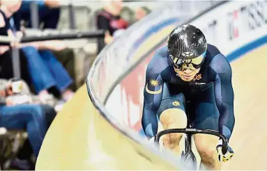  ?? By LIM TEIK HUAT ?? Sheer joy: Azizulhasn­i Awang competing in the third round of the UCI Track World Cup in Berlin, Germany. Right: Azizulhasn­i rejoicing after winning the bronze medal in the keirin event on Saturday.