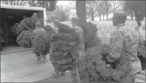  ?? Submitted photo ?? WREATHS STORED: Soldiers and airmen of the Arkansas National Guard load wreaths for storage.