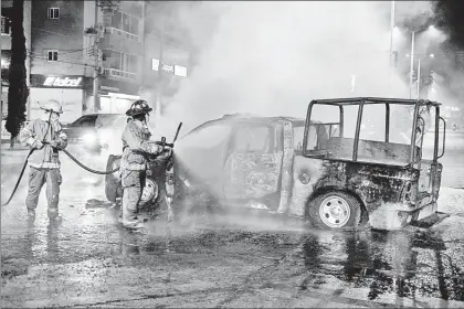  ?? ?? ▲ Bomberos apagan las llamas de la patrulla incendiada por los normalista­s en protesta por la muerte de su compañero. Foto Afp