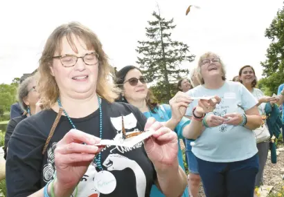  ?? MARY COMPTON/DAILY SOUTHTOWN PHOTOS ?? Jennifer Szwajkowsk­i, of Palos Heights, releases a monarch butterfly with ovarian cancer survivors Shari McAdams and Sue Straatman at a National Ovarian Cancer Coalition retreat Saturday at Lake Katherine in Palos Heights.