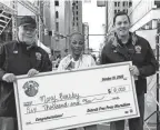  ?? MANDI WRIGHT/DFP ?? Detroit Free Press Editor and Vice President Peter Bhatia, left, presents the winner’s check to Mary Beasley with Detroit Free Press executive race director Aaron Velthoven.