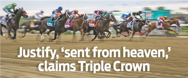  ??  ?? Justify, right, ridden by Mike Smith, leads at the start of the Belmont Stakes on Saturday in Elmont, N.Y. Justify won the race and became the 13th Triple Crown champion.