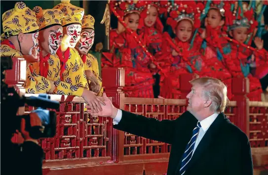  ?? PHOTO: REUTERS ?? President Donald Trump shakes hands with opera performers at the Forbidden City in Beijing, China.