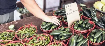  ?? AP ?? Mao Lee sells produce grown on her family farm in Eagan, Minnesota, called Lee Farms, at the Maple Grove Farmers’ Market on August 17.