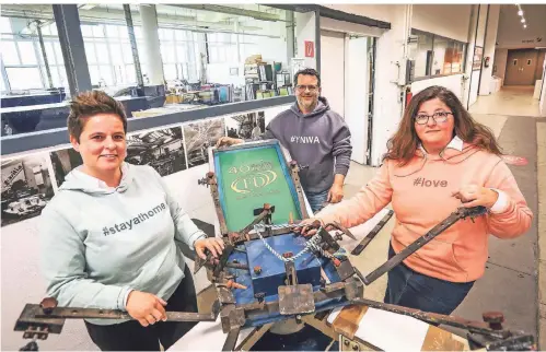  ?? RP-FOTO: HANS-JUERGEN BAUER ?? Die Geschwiste­r (v.l.) Daniela Doliwa, Enrico Doliwa und Claudia Doliwa an einer alten Druckmasch­ine.