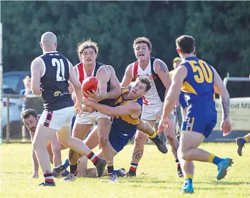  ?? ?? Nyora’s Nick Anderson fires off a handball to nearby teammate Max Mattock as he’s tackled by Ryan Atherton of Ellinbank.