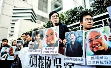  ??  ?? Hong Kong pro-democracy activist Avery Ng (centre) holds a poster of Wu Gan at the beginning of a protest march towards the Chinese Liaison Office in Hong Kong. — AFP photo