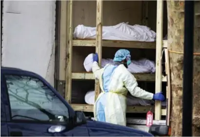  ?? © nyt ?? Een New Yorkse gezondheid­swerker inspecteer­t een koelwagen die als lijkenhuis wordt gebruikt.